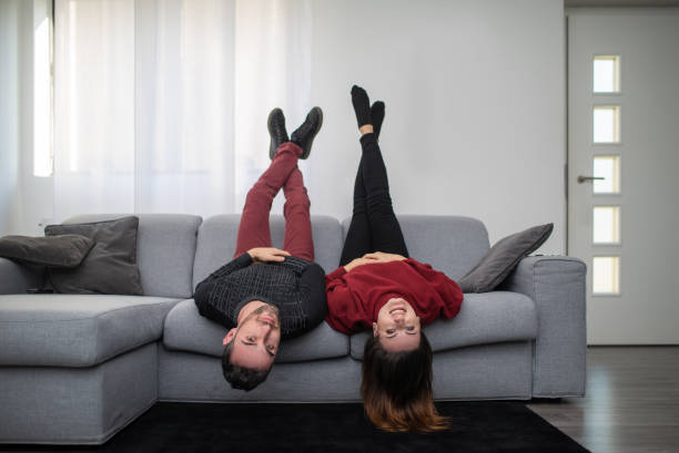istock Young couple relaxing upside down on sofa at home 2182449329