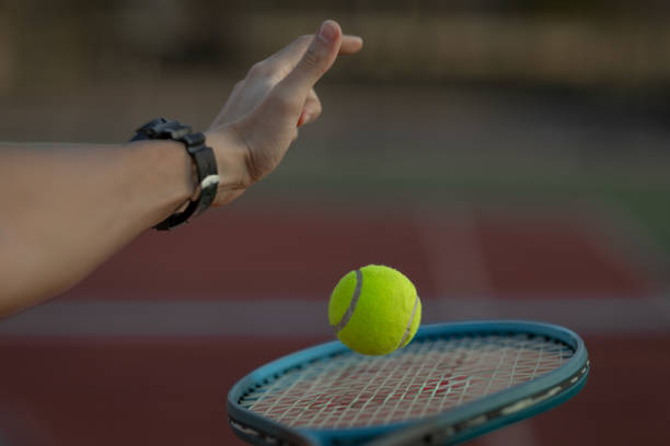 istock Unknown tennis player bounces the ball on his racket 2182452967