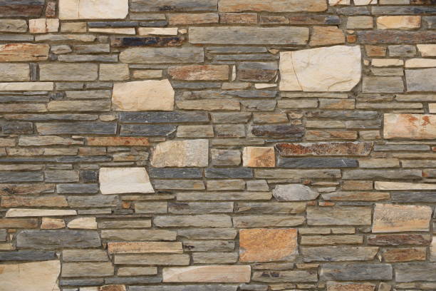 istock Stacked stone brick wall. Stone cladding wall made of natural grey rocks 2182453038