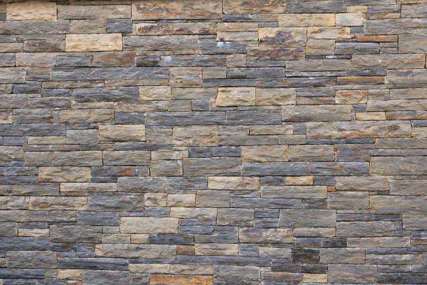 istock Stacked stone brick wall. Stone cladding wall made of natural grey rocks 2182453052