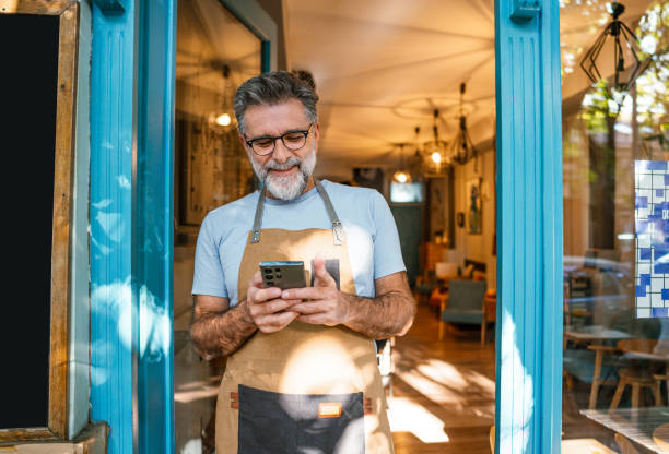 istock Mature male coffee shop owner using phone 2182453995