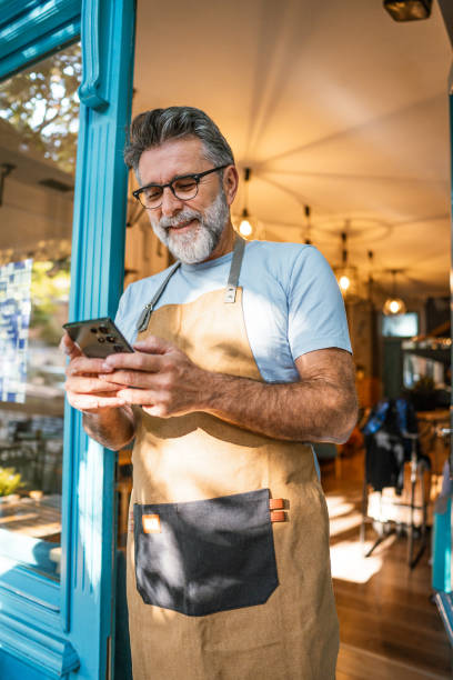 istock Mature male coffee shop owner using phone 2182454072