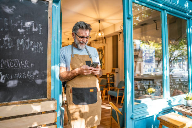 istock Mature male coffee shop owner using phone 2182454093