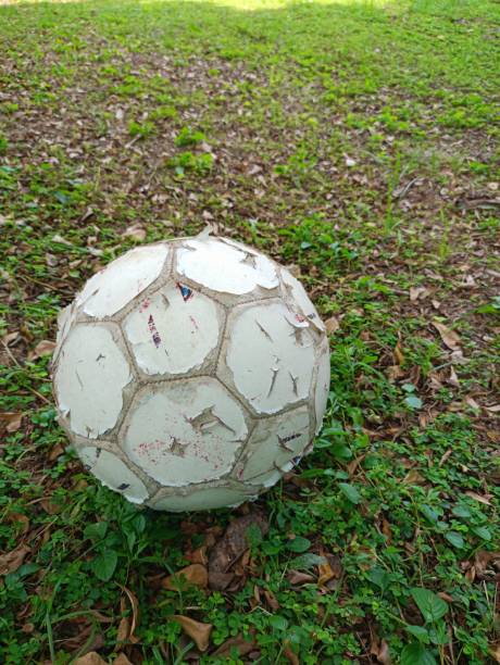Old soccer ball lying on the street, sport and exercise