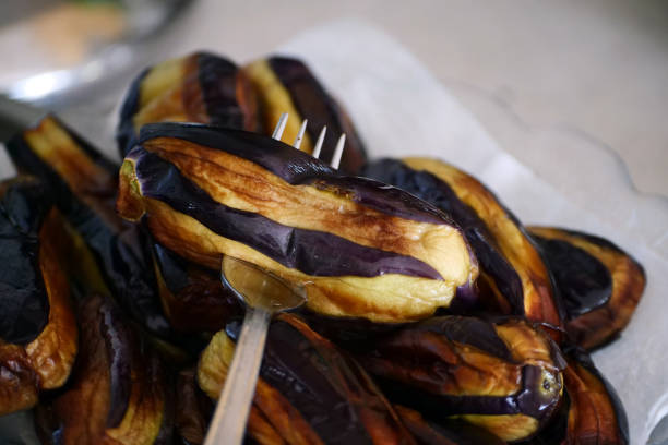 woman's hands salting vegetables. salt concept in the diet. raw eggplant. seasoning food.