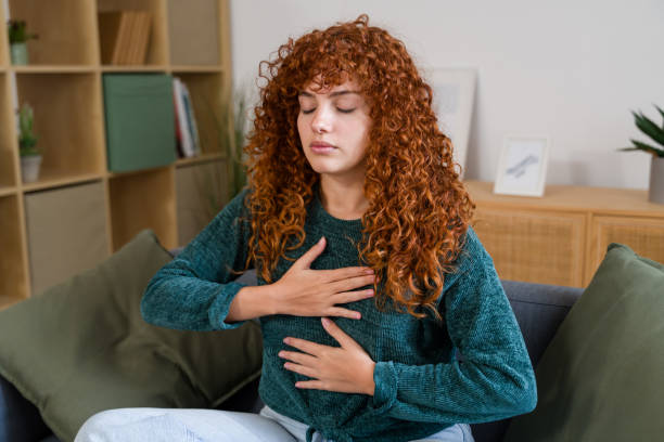 istock Serene woman practicing diaphragmatic breathing on sofa at home 2182470660