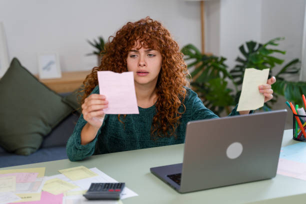 istock Stressed freelancer checking domestic bills and calculating expenses at home office desk 2182473241