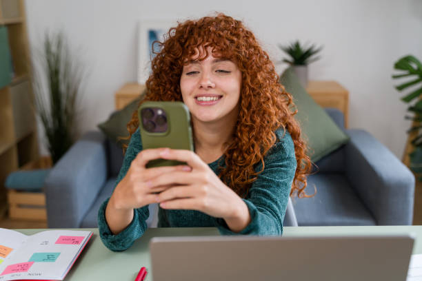 istock Happy freelancer using smartphone and laptop at home office 2182473370