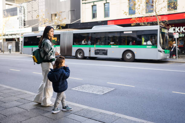 istock Young Asian mother waiting for bus with her toddle 2182478656