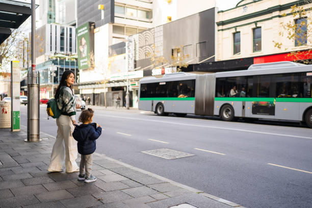 Young Asian mother waiting for bus with her toddle