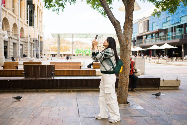 asian woman vlogging using mobile phone -in city perth