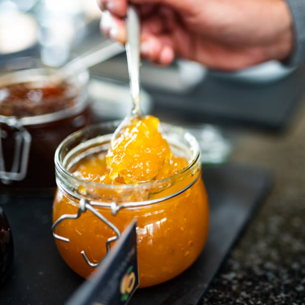 istock Chef taking apricot jam with spoon from jar in restaurant buffet 2182484582