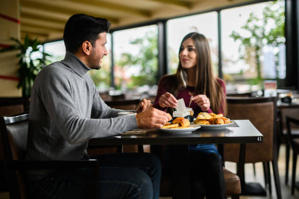 istock Young couple enjoying breakfast and conversation at a cafe 2182484892