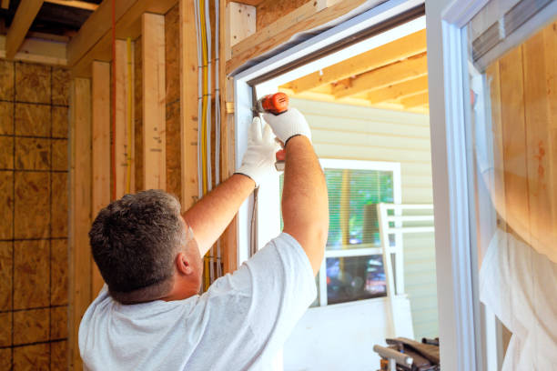istock Carpenter uses screwdriver to install a new home front door 2182487284