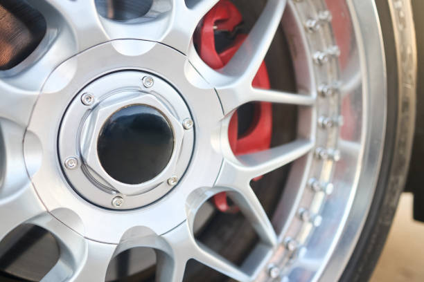 istock Alloy wheel rim plug and red brake caliper selective focus close up. 2182488899