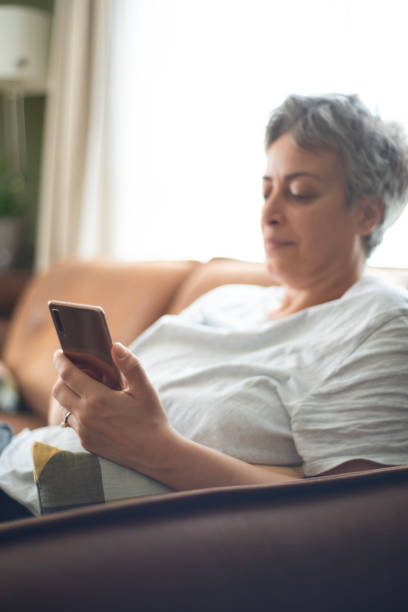 istock Woman using mobile phone at home 2182489127
