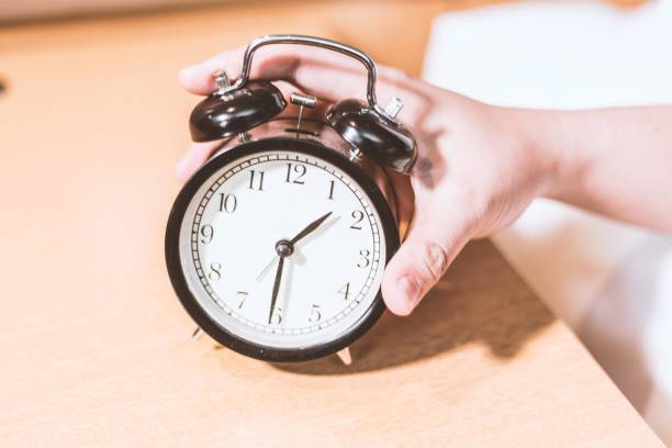 istock A hand is turning off the alarm clock. 2182489167