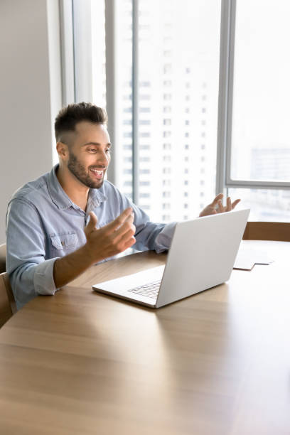 istock Cheerful Latin entrepreneur man talking on video call at laptop 2182496625