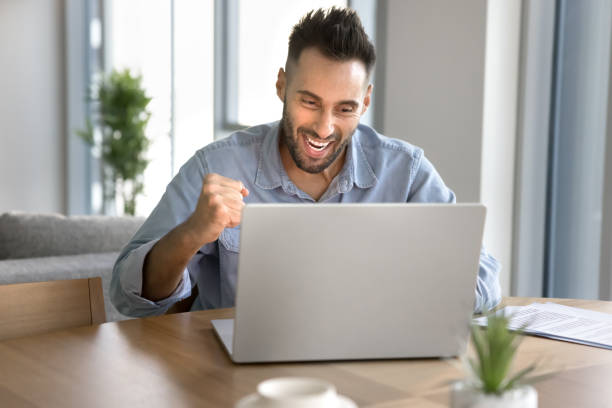 istock Cheerful excited young entrepreneur man making winner hand 2182496827