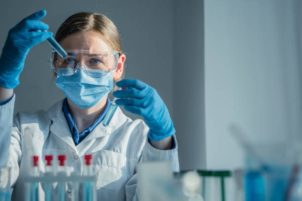 istock A dedicated scientist is conducting a detailed experiment within a wellequipped laboratory, utilizing various test tubes and a precision pipette for their meticulous research work 2182496948