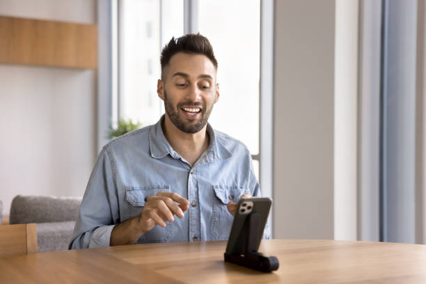 istock Happy Hispanic influencer man speaking at mobile phone web camera 2182504697