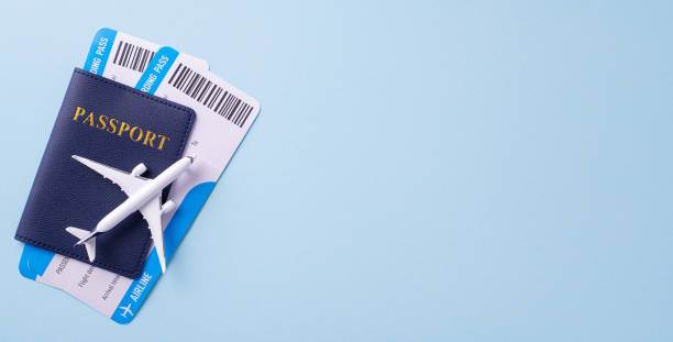 istock Flat lay image of a passport with airplane model and boarding passes on a light blue background, symbolizing travel and vacation planning 2182505479