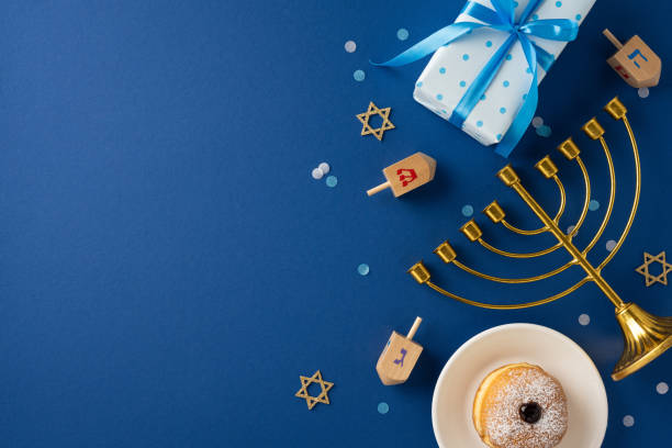 istock A festive Hanukkah scene featuring a menorah, dreidels, and a present on a blue background. Celebrate tradition with this vibrant and colorful holiday setup 2182505517