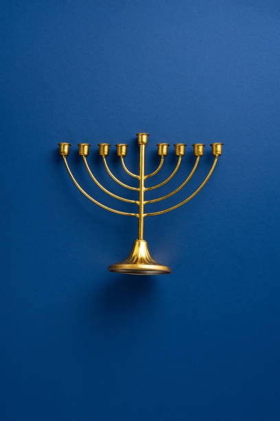 istock A beautiful gold menorah stands gracefully against a rich vertical blue backdrop, perfect for celebrating Hanukkah traditions and Jewish culture 2182505541