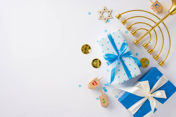 istock Top view of a Hanukkah celebration setup featuring blue and white gift boxes, a menorah, dreidels, and Star of David symbols 2182505552