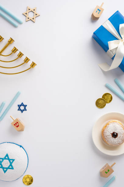 istock Vertical image depicting a Hanukkah celebration with traditional elements such as a menorah, dreidels, and festive treats 2182505564