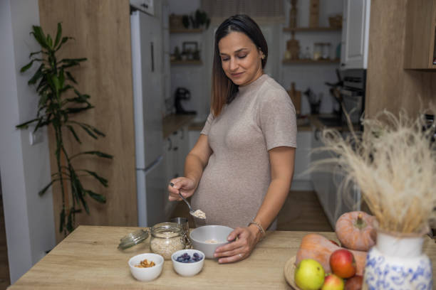 istock A satisfied pregnant woman preparing healthy breakfast while standing in the kitchen. 2182510035