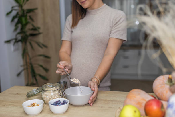 istock A satisfied pregnant woman preparing healthy breakfast while standing in the kitchen. 2182510318
