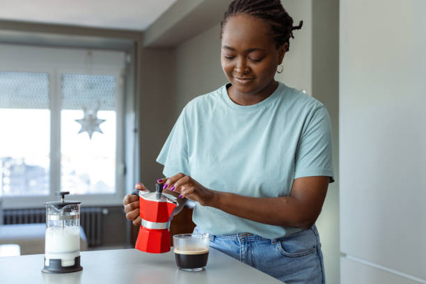istock Woman preparing fresh coffee in a modern kitchen setting 2182514889