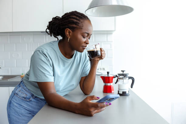 istock Woman enjoying morning coffee while browsing her smartphone at home 2182514891