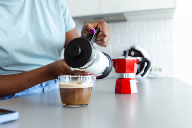 istock Woman making coffee with a French press in a modern kitchen 2182514892