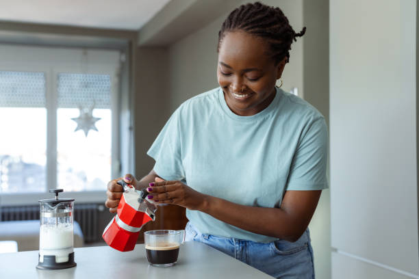 istock Smiling woman making coffee with a moka pot in a modern kitchen 2182514968
