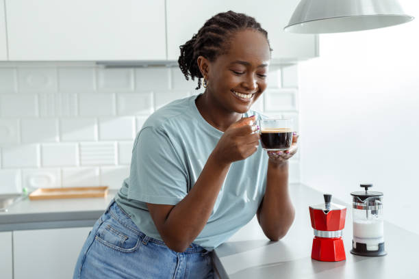istock Smiling woman enjoying coffee in a modern kitchen setting 2182515039
