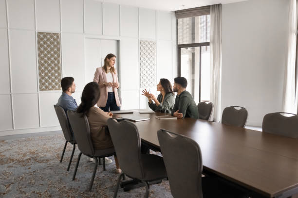 istock Serious female boss standing at large office meeting table 2182515925