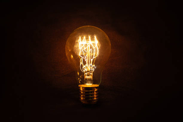 istock Vintage incandescent light bulb glows on black background. Think different, concept. Creative idea. Electricity 2182516377