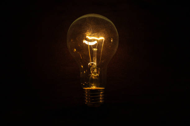 istock Vintage incandescent light bulb glows on black background. Think different, concept. Creative idea. Electricity 2182516527