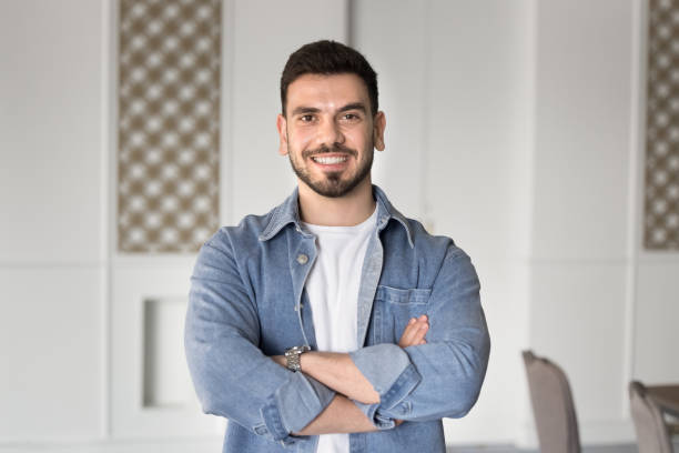 istock Happy handsome Middle Eastern businessman standing indoors with hands crossed 2182518758