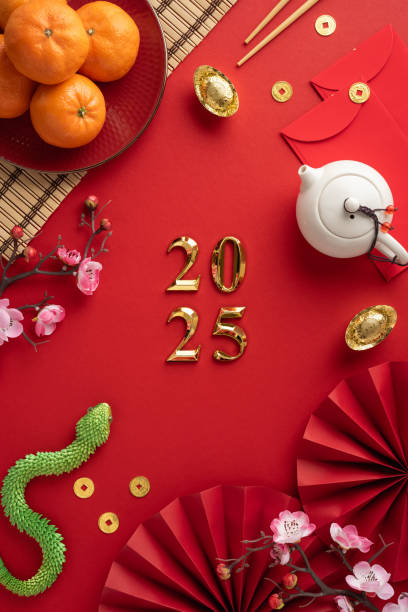 istock Chinese New Year flat lay vertical celebration items including red envelopes, oranges, flowers, and tea set on a red background 2182522011