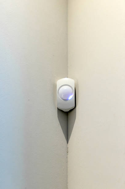 istock Alarm system detector on a wall with space for text on a grey white background and in portrait format. 2182524623
