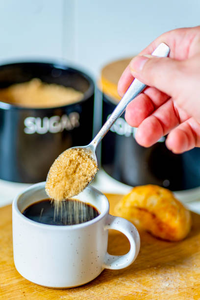 istock Demerara sugar falling from a silver teaspoon into a small cup of hot espresso coffee,in a domestic kitchen,Worcestershire,United Kingdom. 2182537348