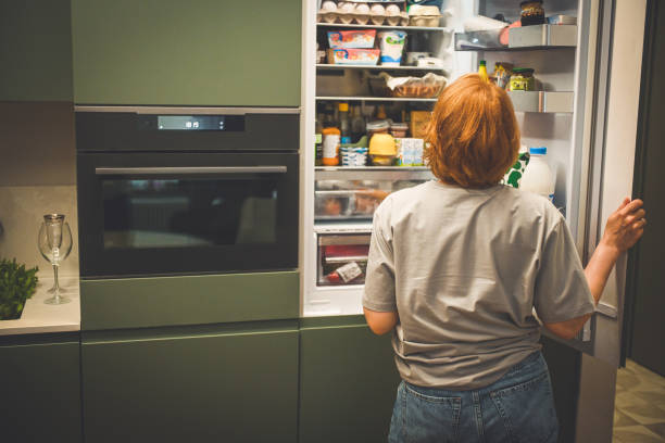 istock woman choosing food in the refrigerator 2182540102