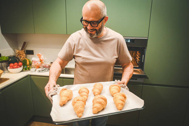 istock man baking croissants in the kitchen 2182542106