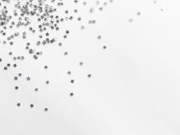 istock Silver star confetti on minimalist white background for festive designs 2182548653