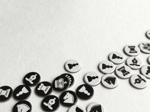 Chess themed tokens on white surface. Strategic game pieces in black and white