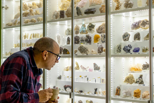 istock Geologist sips coffee while looking at his mineral collection 2182552548