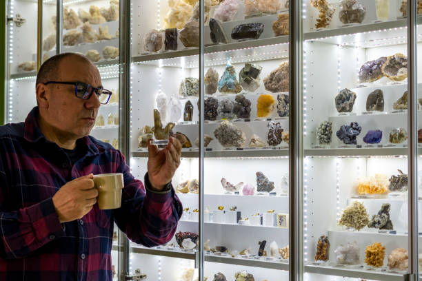 istock Geologist sips coffee while looking at his mineral collection 2182552847